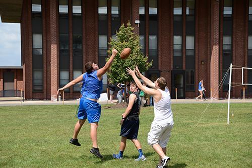 Football students playing football in front of dorms
