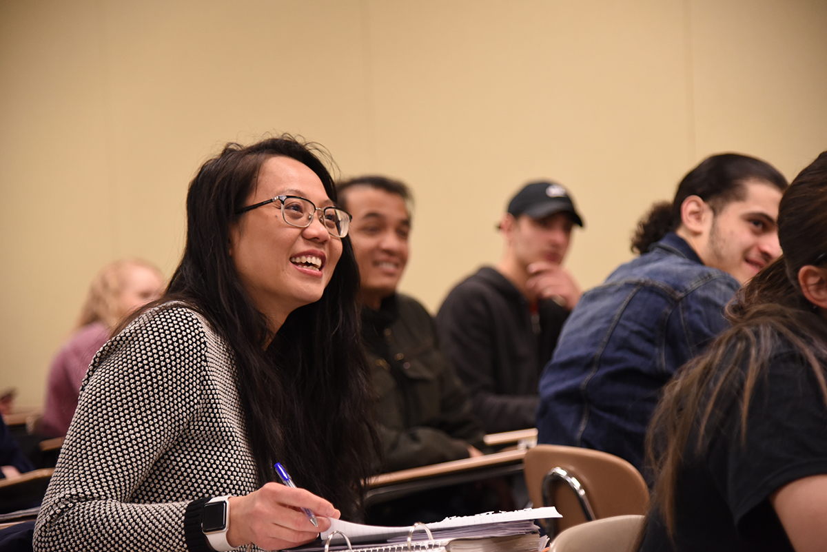 Students smiling, sitting in class listening
