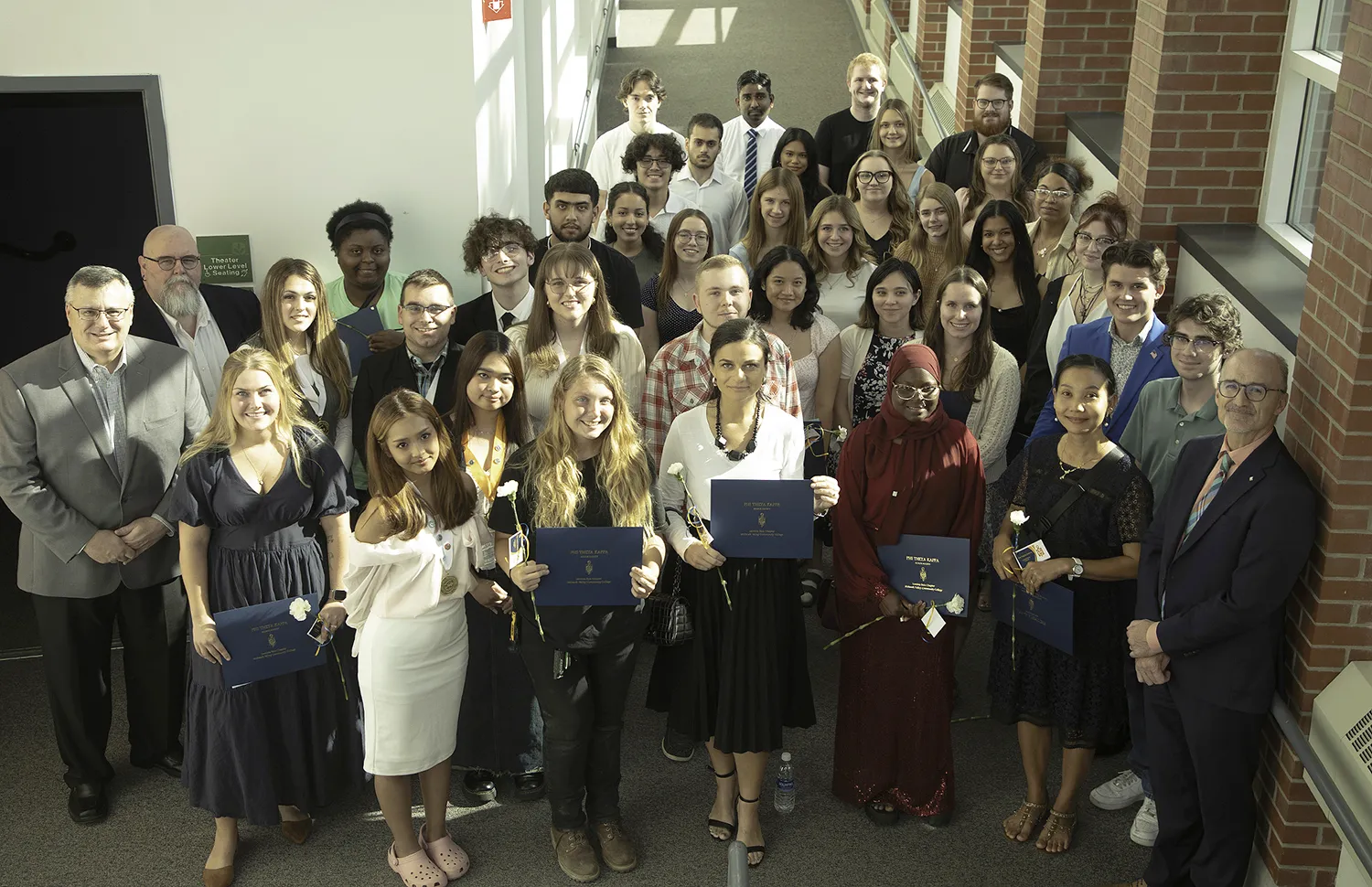 Group of MVCC students, faculty and staff standing on stairs, looking up, smiling